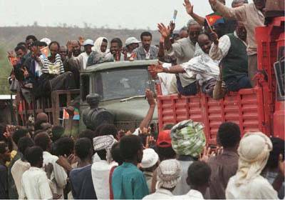 Eritreans expelled from Ethiopia wave to villagers in Om Hagar 17 June as they arrive in this border village, 500km west of Asmara. A group of 750 Eritreans were expelled from Ethiopia who are treating the 130,000 Eritreans on thier soil with increasing suspicion since the war between the two countries erupted 06 May. 